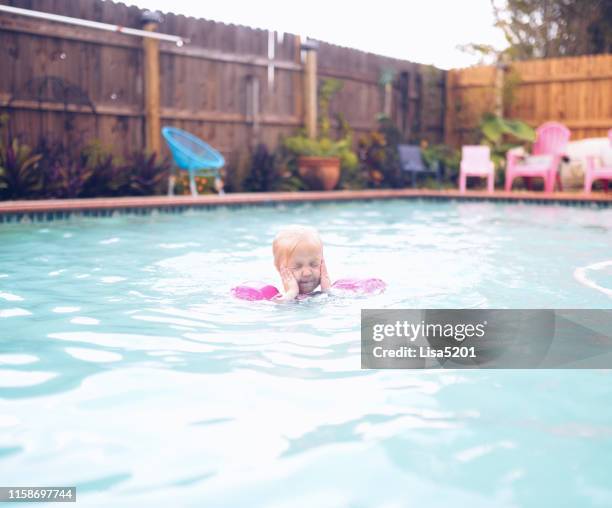 little girl wearing swimmers in a pool - red eyes stock pictures, royalty-free photos & images