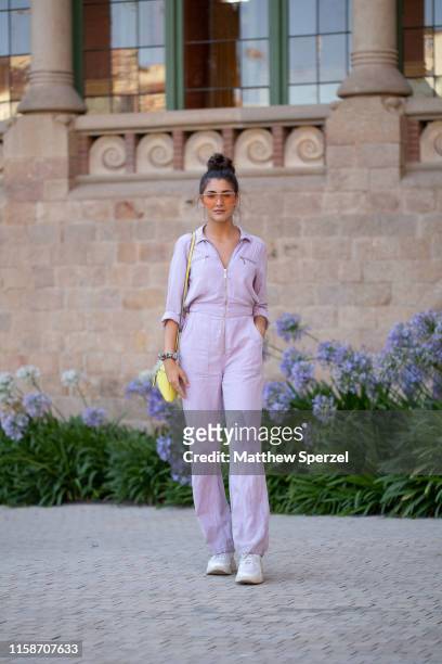 Guest is seen on the street attending 080 Barcelona Fashion Week wearing lavender jumpsuit with yellow bag and sunglasses on June 27, 2019 in...