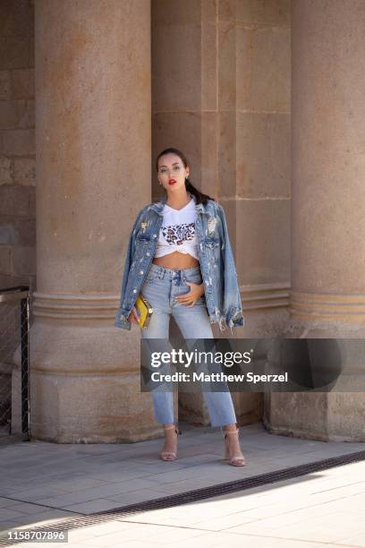 Guest is seen on the street attending 080 Barcelona Fashion Week wearing denim and hand painted jacket, faded blue jeans, and a white graphic tshirt...