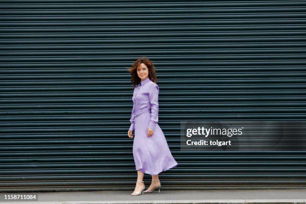 beautiful  woman in urban background - purple dress stock pictures, royalty-free photos & images