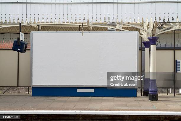 blank british billboard at a railway station - treinstation stockfoto's en -beelden