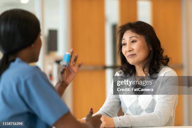 korean asthmatic woman meets with doctor - asthma in adults imagens e fotografias de stock