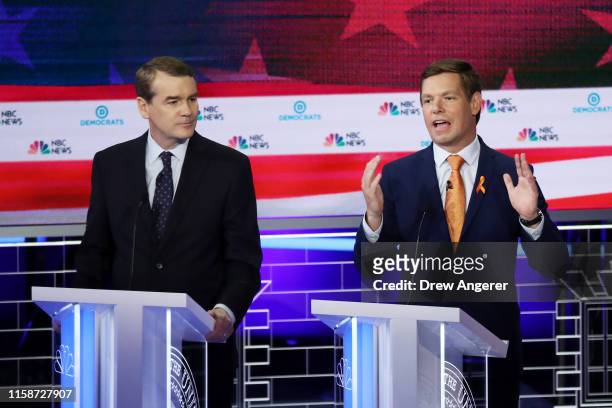 Democratic presidential candidates Sen. Michael Bennet looks on as Rep. Eric Swalwell speaks during the second night of the first Democratic...