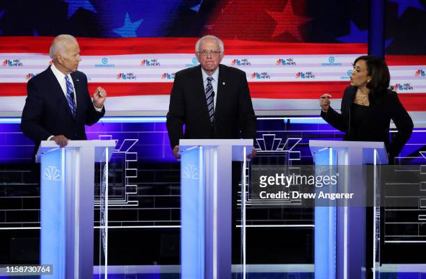 Sen. Kamala Harris and former Vice President Joe Biden speak as Sen. Bernie Sanders looks on during the second night of the first Democratic...