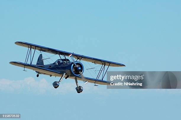 biplane stearman kadet flying in sky - airplane clear sky stock pictures, royalty-free photos & images