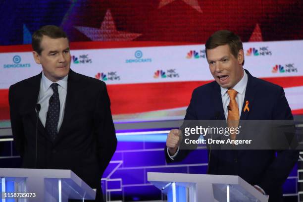 Rep. Eric Swalwell speaks as Sen. Michael Bennet looks on during the second night of the first Democratic presidential debate on June 27, 2019 in...