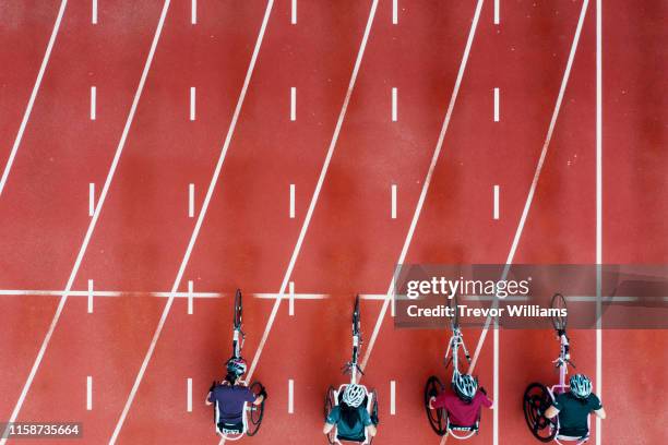 view from directly above four women racing in wheelchairs at the starting line - finishing line stock pictures, royalty-free photos & images