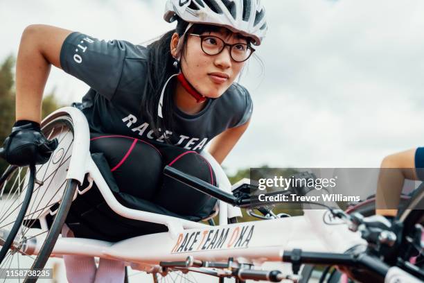 young female wheelchair racer before a competition at a track and field event - hartnäckigkeit stock-fotos und bilder