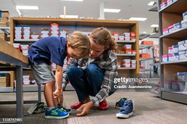 成熟的女人為她的兒子買鞋 - women trying on shoes 個照片及圖片檔