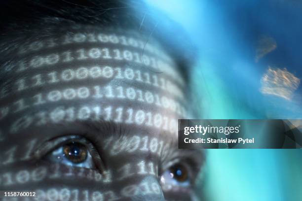 closeup view of womans face lit by binary code - binary code face stock pictures, royalty-free photos & images