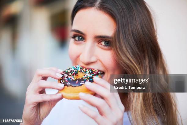 young beautiful blonde millenial posing for social media. holding a donut. - biting donut stock pictures, royalty-free photos & images