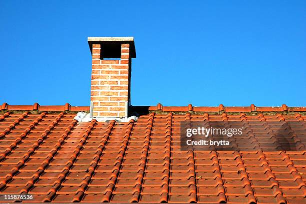 chimney and orange clay tiles against a blue sky - chimney stock pictures, royalty-free photos & images