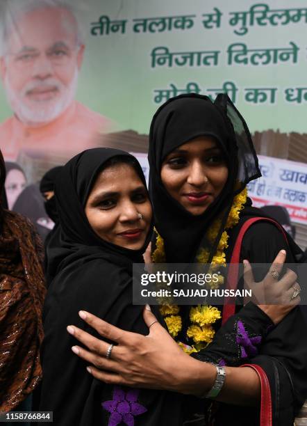 Muslim women hug each other as they celebrate the passage of a law to outlaw Triple Talaq, or "instant divorce," at an event organised by the ruling...