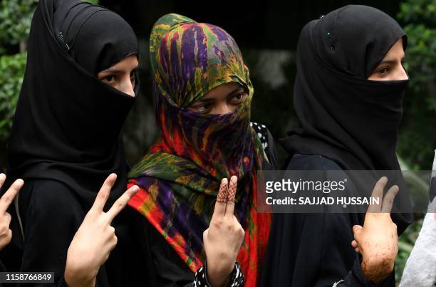 Muslim women pose with a gesture as they celebrate the passage of a law to outlaw Triple Talaq, or "instant divorce," at an event organised by the...