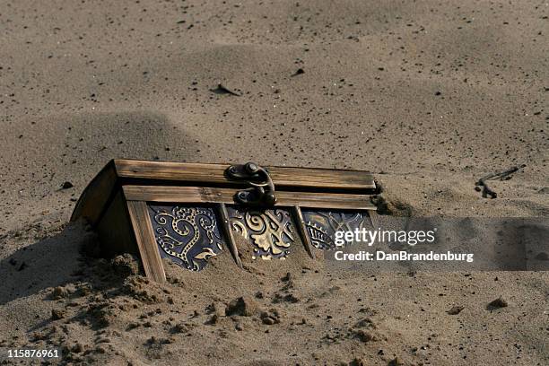 treasure chest - buried in sand stockfoto's en -beelden