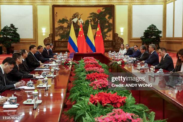 China's President Xi Jinping speaks to Colombia's President Ivan Duque during a bilateral meeting at the Great Hall of the People in Beijing on July...