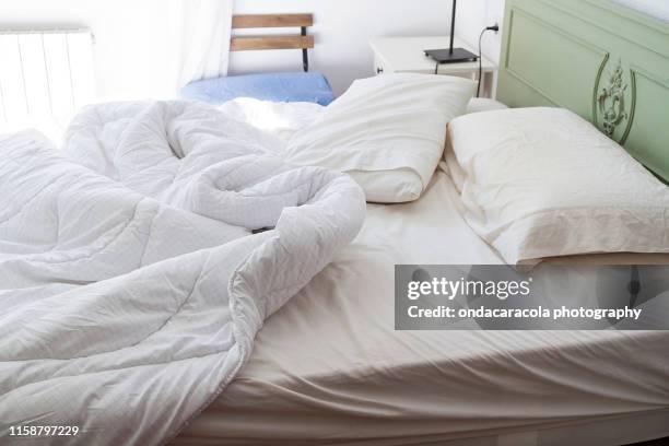 a real messy bed - sheet bedding stock-fotos und bilder