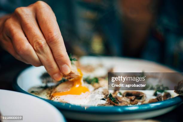 vrouw eten het ontbijt met roerei - breakfast eggs stockfoto's en -beelden