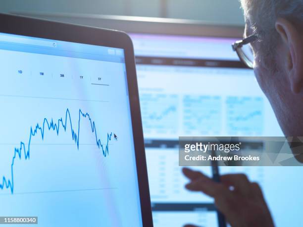 financial services, stock analyst researching share price data of a company on the computer - scrutiny foto e immagini stock