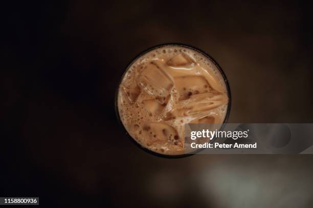 glass of iced coffee on cafe table, overhead view - iced coffee stock pictures, royalty-free photos & images