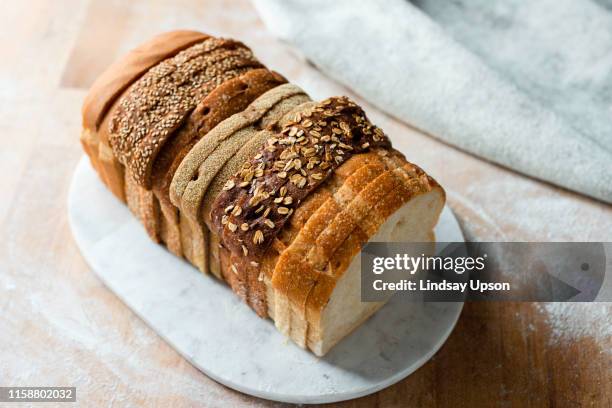 sliced loaf made up of variety of white and wholemeal slices on cutting board, high angle view - granary stock pictures, royalty-free photos & images