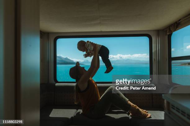 mother playing with baby in motorhome, wanaka, taranaki, new zealand - family new zealand stock-fotos und bilder