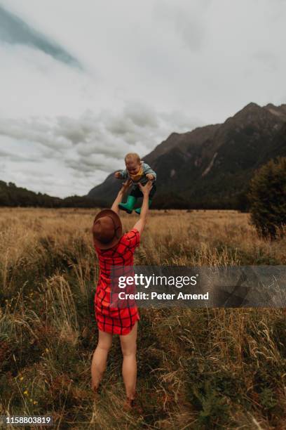 mother playing with baby in wilderness, queenstown, canterbury, new zealand - family new zealand stockfoto's en -beelden