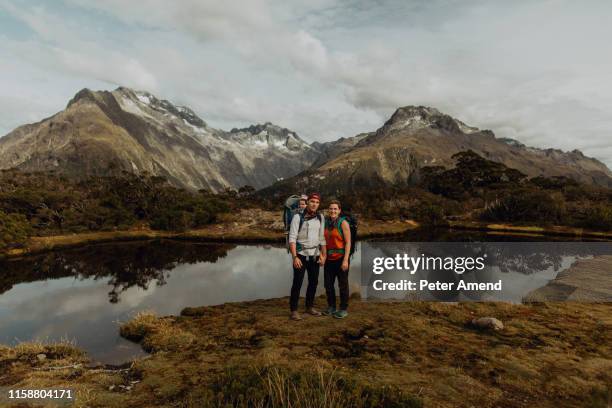 hiker couple with baby by lake, queenstown, canterbury, new zealand - queenstown new zealand foto e immagini stock