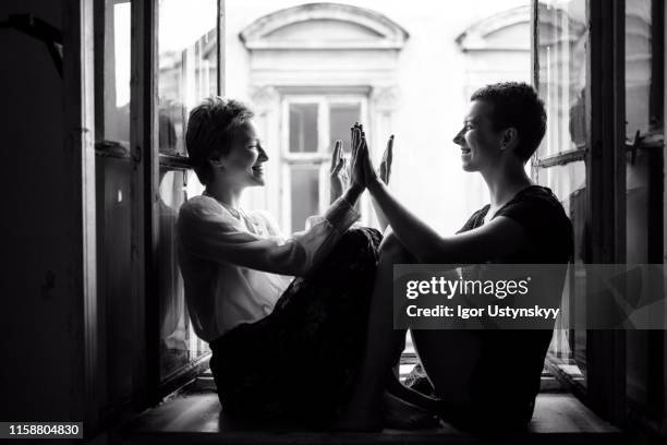 beautiful girlfriends doing clapping game - man and woman holding hands profile stock-fotos und bilder