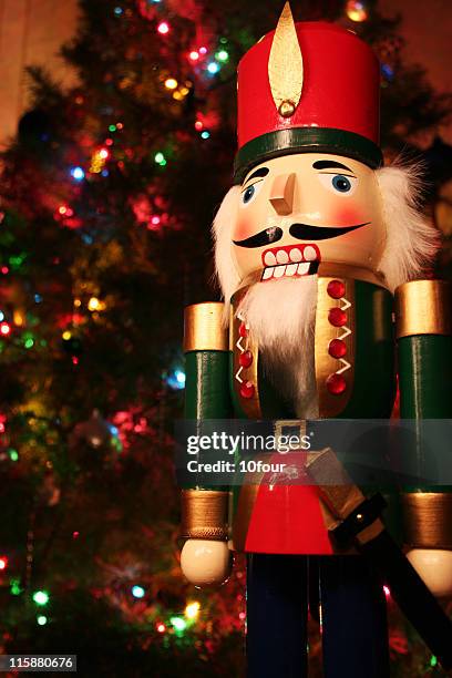 a holiday nutcracker and a christmas tree on the back - nutcracker stock pictures, royalty-free photos & images