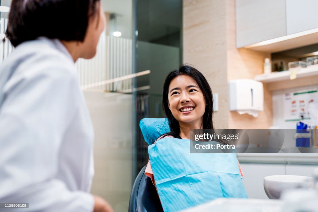 Paciente sonriente mirando al dentista en la clínica