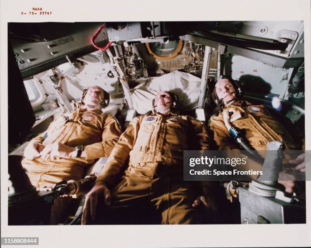 The three US prime crewmen of the Apollo-Soyuz Test Project lying in their couches in the Apollo Command Module trainer in Building 35 of NASA's...