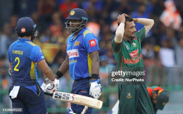 Sri Lankan cricketer Angelo Mathews talks with Kusal Mendis as Bangladesh cricketer Shafiul Islam looks on during the 3rd One Day International...