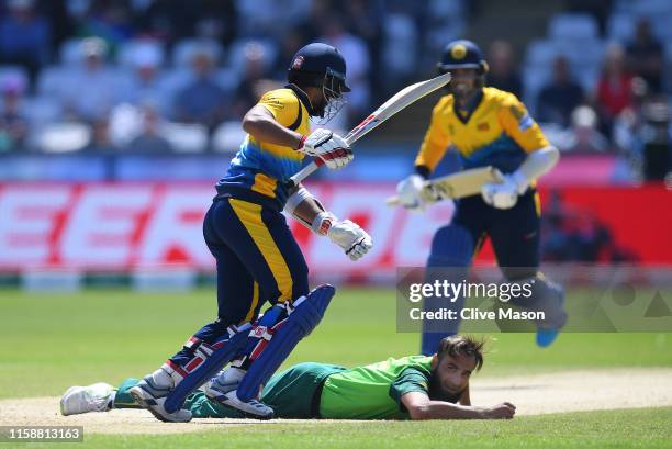 Imran Tahir of South Africa falls on the floor as Kusal Mendis and Dhanajaya de Silva of Sri Lanka add more runs during the Group Stage match of the...