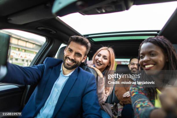 multi-ethnic group of friends taking selfie during car ride - ethnic woman driving a car stock pictures, royalty-free photos & images