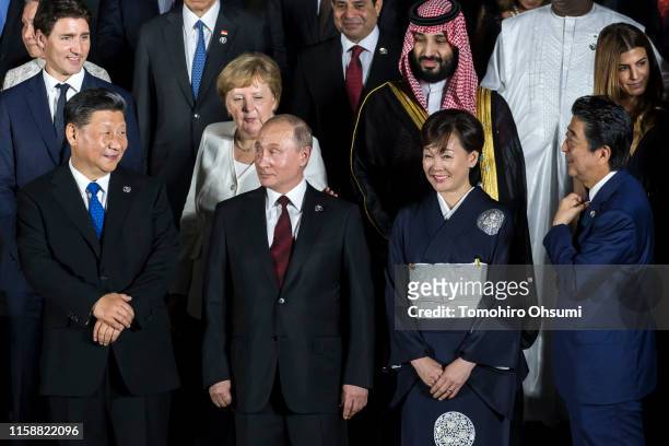 Japan's Prime Minister Shinzo Abe speaks to China's President Xi Jinping as Russia's President Vladimir Putin and Japan's first lady Akie Abe look on...