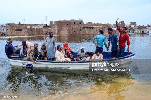 Soldiers use a boat to evacute local residents from floodwaters after heavy monsoon rains in Hyderabad on July 31 some 160 km east of the southern...