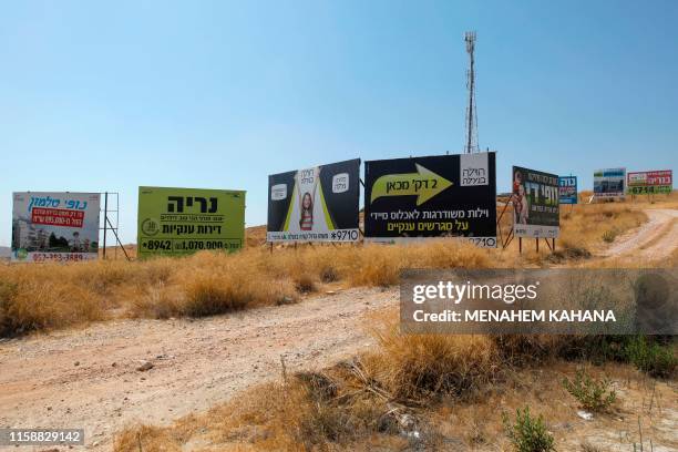 Roadside billboards advertising newly constructed apartments for sale in settlements are seen near the West Bank Settlement of Nili on July 31, 2019....