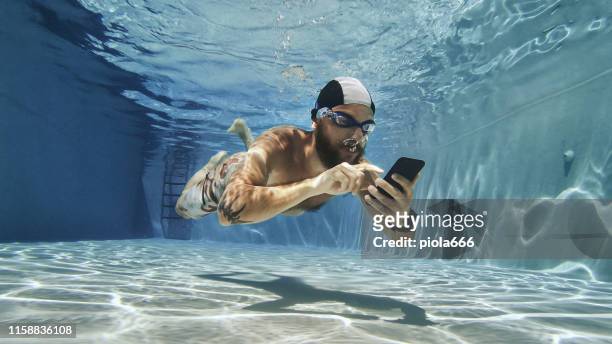 uomo maniaco del lavoro che usa il telefono cellulare sott'acqua - crazy pool foto e immagini stock
