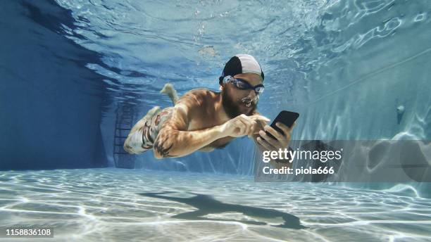 workaholic man met behulp van mobiele telefoon onderwater - man in swimming pool stockfoto's en -beelden