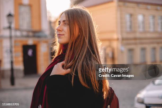 portrait of young thoughtful woman walking on street - student day dreaming stock pictures, royalty-free photos & images