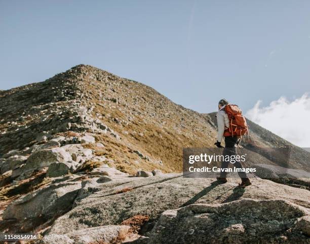 appalachian trail hiker nears the summit of mount katahdin in maine. - hiking appalachian trail stock pictures, royalty-free photos & images