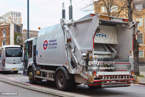 image of a garbage truck driving down a road - garbage truck driving stock pictures, royalty-free photos & images