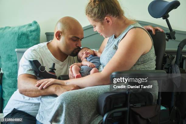 couple with newborn baby, mother is disabled. - disabilitycollection stockfoto's en -beelden