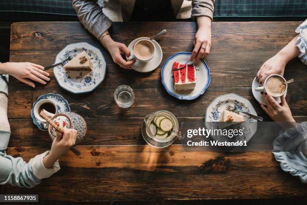 top view of friends sitting at wooden table in a cafe - cup of tea from above fotografías e imágenes de stock