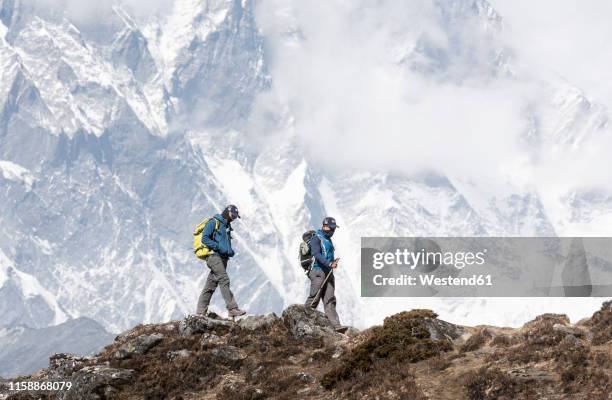 nepal, solo khumbu, everest, mountaineer and sherpa walking in the mountains - sherpa nepal stock pictures, royalty-free photos & images