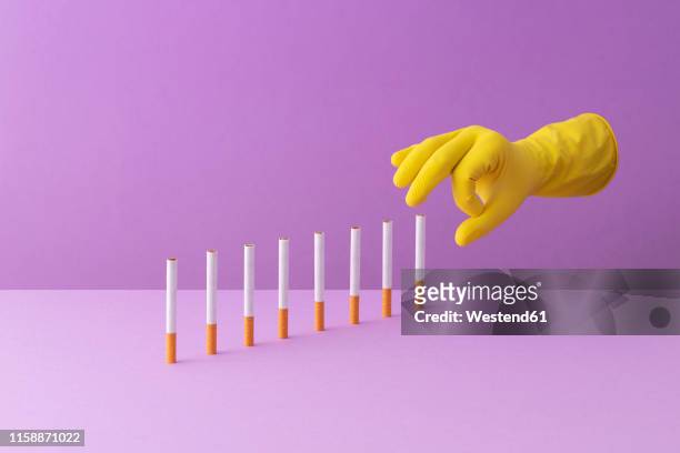 hand shoving cigarettes in a row, creating a domino effect - 3d hand stock-grafiken, -clipart, -cartoons und -symbole
