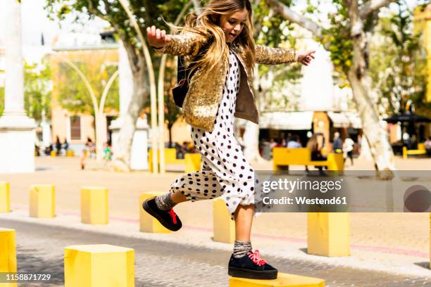 girl jumping from bollard to bollard - bollards fotografías e imágenes de stock