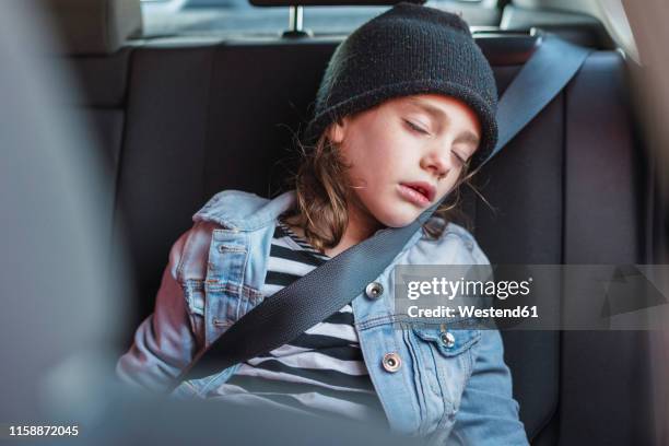 portrait of sleeping little girl on back seat of a car - kid car seat stock pictures, royalty-free photos & images