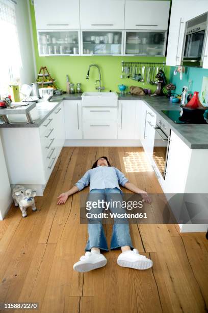 mature woman lying on the floor in kitchen at home - dead body floor stock pictures, royalty-free photos & images